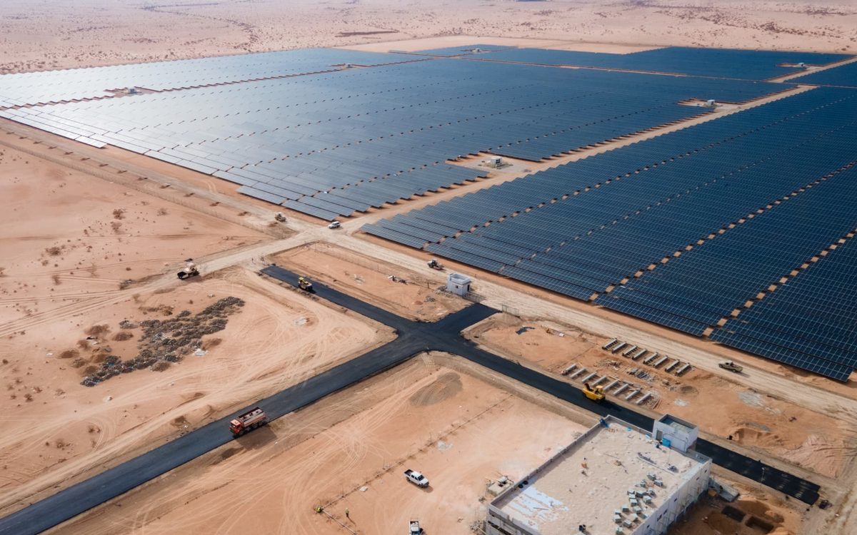 Long rows of solar modules on tracker frames under a clear sky