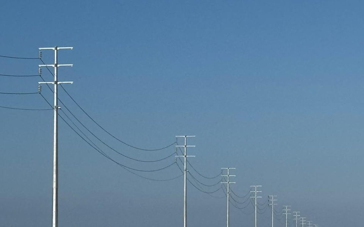 A distribution line of concrete poles receding across open ground near Berbera
