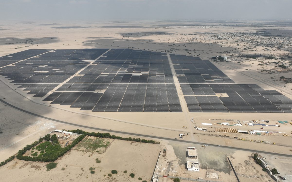 Aerial view of the completed Aden I solar plant, its array blocks reaching to the edge of the city