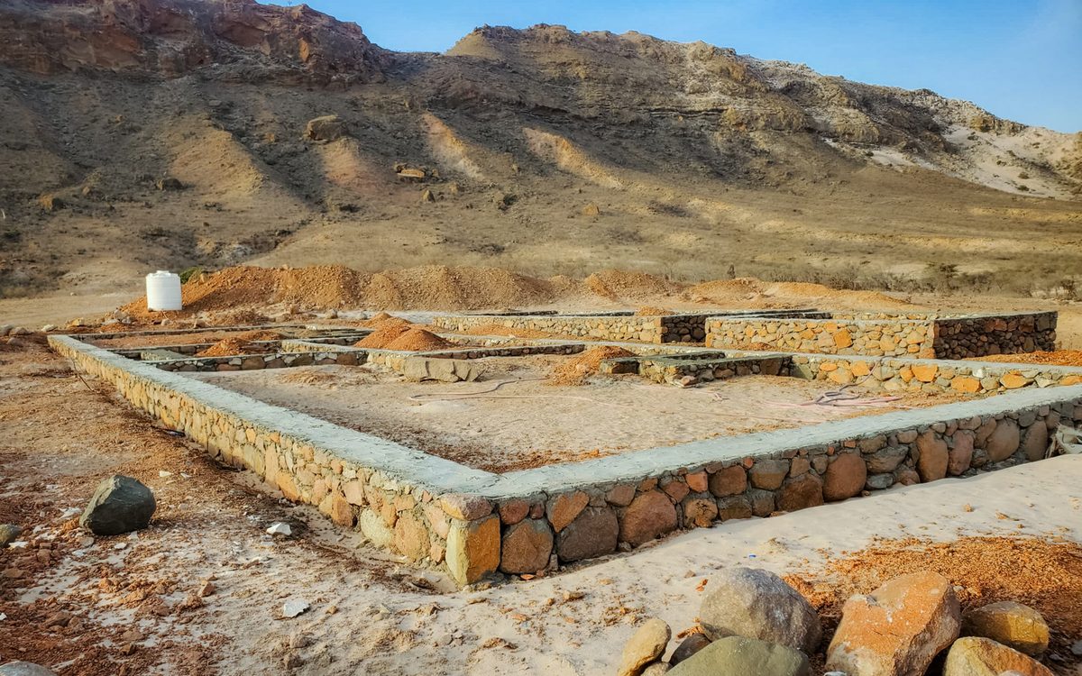 Stone-walled foundation works on the rocky Socotra site