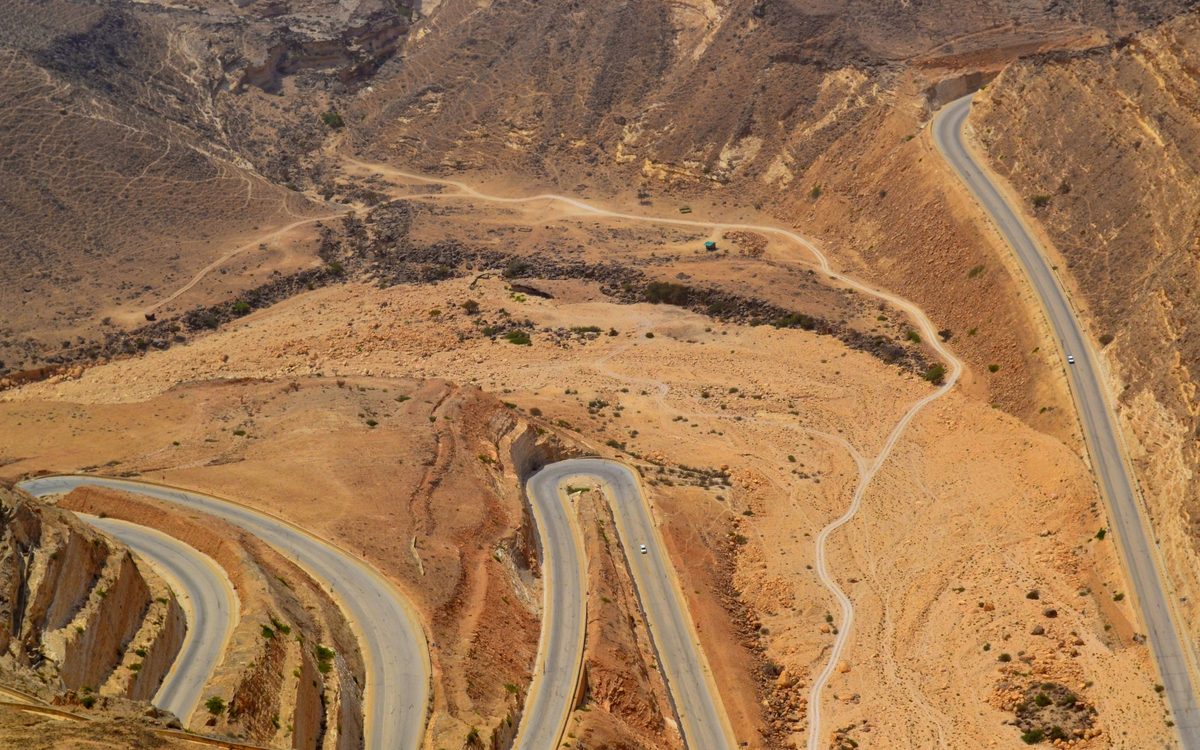 Aerial view of a track cutting across the red rock hills near Al Mukalla