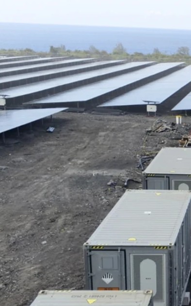 Battery storage containers beside a solar array under construction