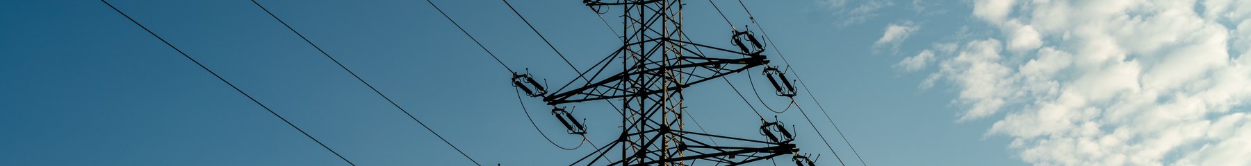 A transmission pylon and conductors against a blue sky
