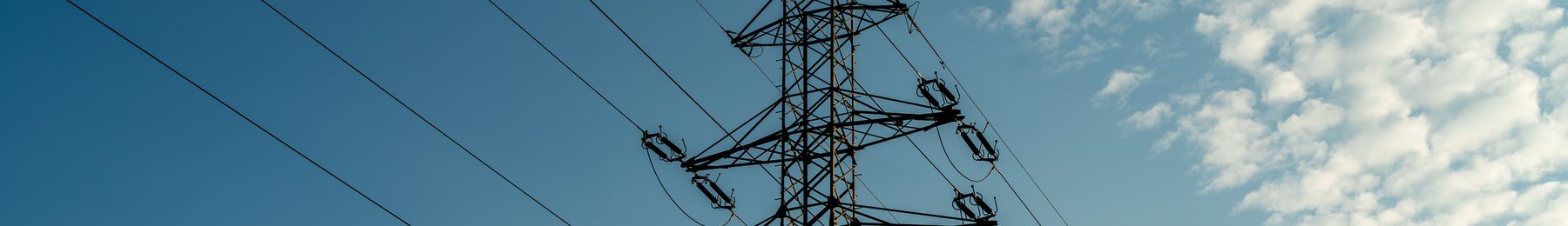 A transmission pylon and conductors against a blue sky