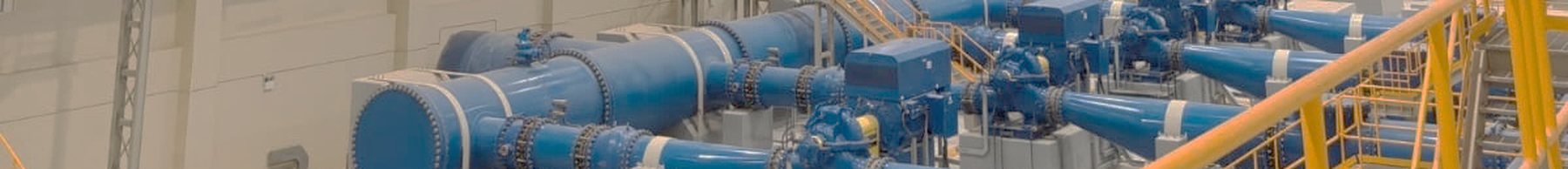 Large blue pipework and valves inside a pumping station